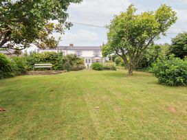 A garden with a house and trees at Nanvivian in Feock near Truro