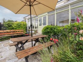 A dining table with an umbrella and benches at Nanvivian in Feock near Truro