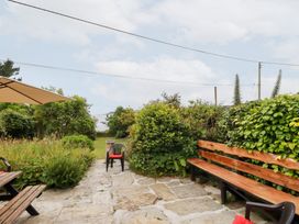 A garden with a bench and umbrella at Nanvivian in Feock near Truro