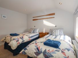 A bedroom with two single beds and blue and white bedding at Criw in Bryncroes near Sarn Meyllteyrn