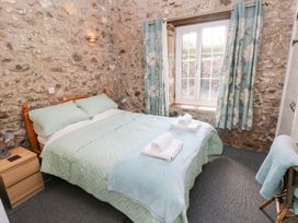 A bedroom with a bed and window at 8 Rogeston Cottages in Haverfordwest