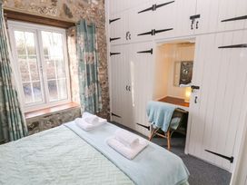 A bedroom with a bed and window at 8 Rogeston Cottages Haverfordwest