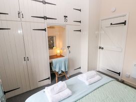 A bedroom with a bed and cupboards at 8 Rogeston Cottages Haverfordwest