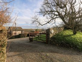 A gate leading to a gravel driveway with buildings and trees at 8 Rogeston Cottages Haverfordwest