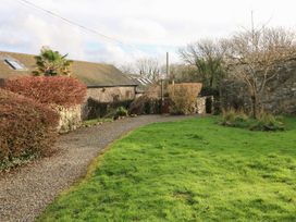 A garden with a pathway and stone walls at 8 Rogeston Cottages Haverfordwest