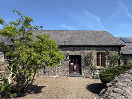 An outdoor view of a stone cottage with a door and windows at 8 Rogeston Cottages Haverfordwest
