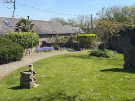 A garden with flowers and a stone wall at 8 Rogeston Cottages Haverfordwest