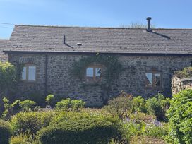 A house with stone walls and windows surrounded by a garden at 8 Rogeston Cottages in Haverfordwest