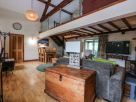 A living room with a sofa and dining area at Pen Glorian in Conwy
