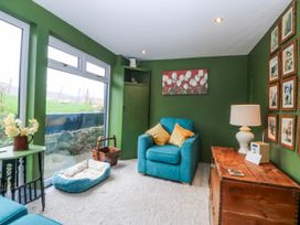 A snug with a sofa and a lamp at Pen Glorian in Conwy