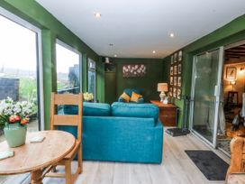 A living room with a sofa and table at Pen Glorian in Conwy