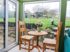 A conservatory with a table and chairs at Pen Glorian Conwy