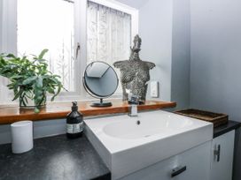 A bathroom with a sink and a mirror at Pen Glorian in Conwy