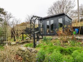 A garden with a shed and pathways at Pen Glorian in Conwy