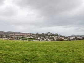 A view of houses on a hill with grass in the foreground at Pen Glorian in Conwy