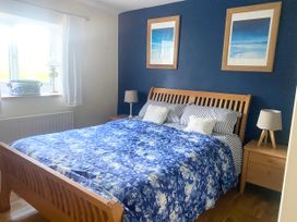 A bedroom with a bed and bedside table at Pen Glorian in Conwy