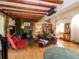 A living room with sofa and armchair at Pen Glorian in Conwy