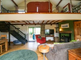 A living room with a staircase and sofa at Pen Glorian in Conwy