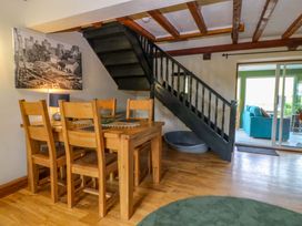 A dining room with a table and chairs and stairs at Pen Glorian in Conwy