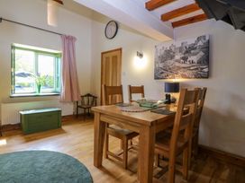 A dining room with a wooden table and chairs at Pen Glorian in Conwy