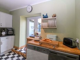 A kitchen with a clock and dish rack at Pen Glorian in Conwy