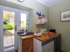 A kitchen with a door and appliances at Pen Glorian in Conwy