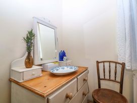 A bathroom with a vanity and mirror at Pen Glorian in Conwy