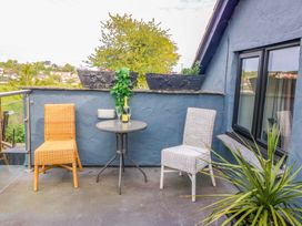 A balcony with two chairs and a table at Pen Glorian in Conwy