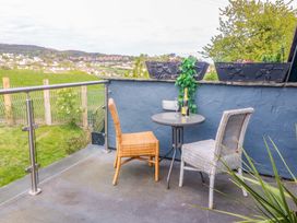 A patio area with a table and chairs at Pen Glorian in Conwy