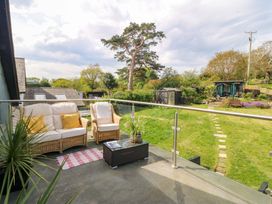A balcony with seating and a view of a garden at Pen Glorian in Conwy