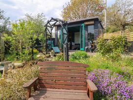 A garden with a bench and a shed at Pen Glorian in Conwy