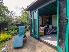 A garden room with furniture and maps inside at Pen Glorian in Conwy