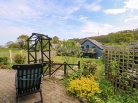 A garden with a chair and plants at Pen Glorian in Conwy
