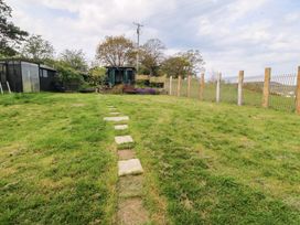 A garden with a stone path leading to a shed at Pen Glorian in Conwy