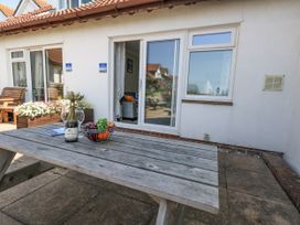 An outdoor seating area with a table and wine at Sea Spray Bowleaze