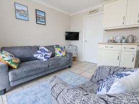A living room with a sofa and television at Sea Spray Bowleaze