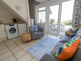 A living room with a washing machine and sofa at Sea Spray in Bowleaze