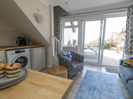 A living room with a washing machine and refrigerator at Sea Spray in Bowleaze