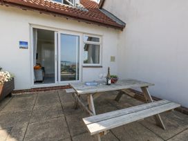 An outdoor seating area with a table and drinks at Sea Spray in Bowleaze