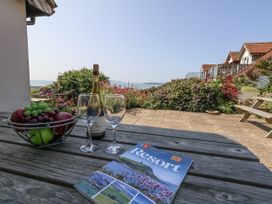 An outdoor area featuring a dining table with wine and fruit at Sea Spray in Bowleaze