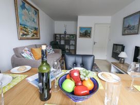 A living room with a fruit bowl and wine bottle at Flat 13, Chesil House in Bridport