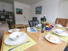 A dining table set with plates and fruit at Flat 13, Chesil House in Bridport