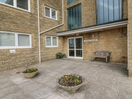 An outdoor entrance area with a bench and planters at Flat 13, Chesil House in Bridport