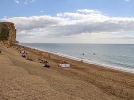 A beach with people relaxing and surfing at Flat 13, Chesil House in Bridport