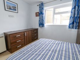 A bedroom with a bed and dresser at Beachcombers, 13 Chesil House in Bridport