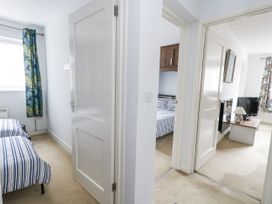 A hallway with doors leading to bedrooms at Beachcombers, 13 Chesil House in Bridport