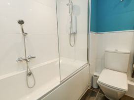 A bathroom with a bathtub and a toilet at Beachcombers, 13 Chesil House, Bridport