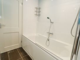 A bathroom with a shower and bathtub at Beachcombers, 13 Chesil House Bridport