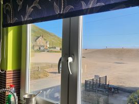 A kitchen window overlooking a beach at Beachcombers, 13 Chesil House, West Bay