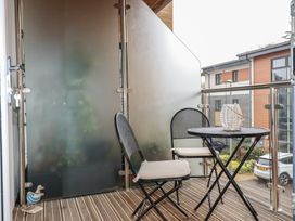 A balcony with two chairs and a round table with a decorative item at 13 Clock Tower Court in Charlestown